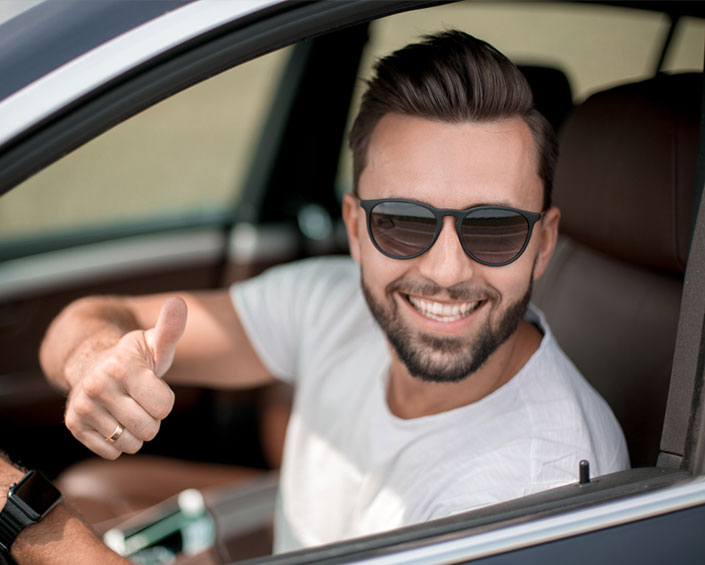 Hombre feliz coduciendo su auto de renta en Morelia.